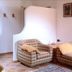 Borcanela Apartments in Moena: cozy living room with plaid sofa, armchair, and tiled floor