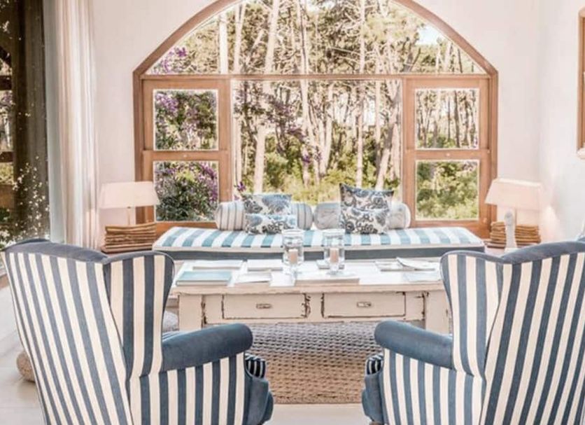 Kala Hotel Boutique in Maldonado seating area with striped armchairs and arched window garden view