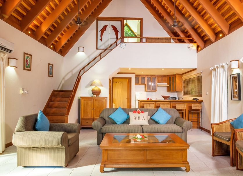 First Landing Beach Resort and Villas in Viseisei: airy villa living room with loft, staircase, and kitchen