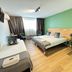 Hotel de Grote Zwaan in De Lutte room with double bed, twin bed, green accent wall and window seating.