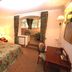 Park Hotel am Schloss, Rieden: cozy guest room with floral bedspread, desk, and sitting area