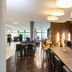 Staycity Aparthotels Heidelberg lobby lounge with dining tables, chandelier lighting and dark wood flooring