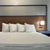 AmericInn by Wyndham Galesburg room with king bed, bedside lamps and wood headboard