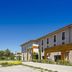 Grand Prix Hôtel & Restaurant in Le Castellet, modern hotel exterior with clear blue sky and landscaped driveway