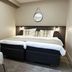 Original Sokos Hotel Rikala in Salo guest room with twin beds, armchair, and round wall mirror