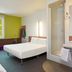 ibis budget Wroclaw Stadion room in Wrocław with twin beds, window, and glass shower enclosure