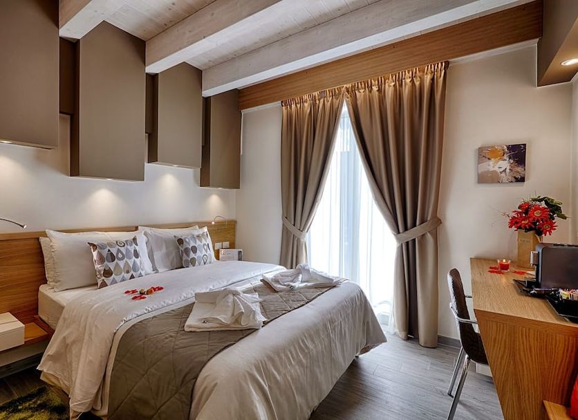 Hospitality Hotel Palermo guest room with double bed, desk, and floor-to-ceiling curtains