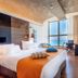 Nof Hotel in Haifa guest room with large ocean-view window, bed, desk, and blue seating