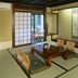 Matsubaya Ryokan Kyoto tatami room with low table, floor cushions and garden-view sliding door