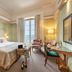 Pousada Viana do Castelo guest room with king bed, chairs by a window, and partial sea view in Viana do Castelo