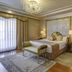 Rixos President Astana in Astana: elegant king bed suite with chandelier, bench, and large window curtains
