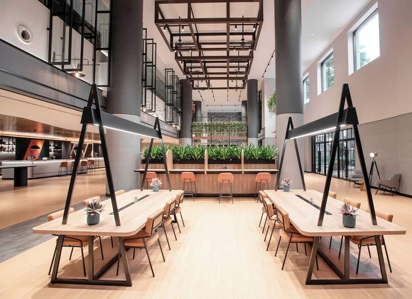 Resorts World Sentosa - Hotel Ora atrium dining space in Singapore with long communal tables and high ceilings