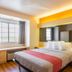 Motel 6 Bernalillo guest room with double bed, window seat, and warm accent lighting