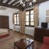 Vettonia in Ávila guest room with double bed, large windows, desk, TV, and chandelier