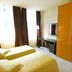 Residence Diamanterosso Terni guest room with two twin beds, desk, mirror and orange wardrobe