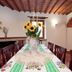 Borgo Nuovo San Martino in Ambra dining room with long table, sunflowers, and wood-beam ceiling