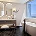 The Leo Kent Hotel, Tucson bathroom with double vanity, oval mirrors, soaking tub and city view