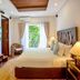 7Stones Boracay in Boracay guest room with king bed, balcony doors, TV, and wood ceiling detail