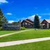 Best Western Northwoods Lodge in Siren with a sign, lawn, and low-rise lodge buildings under blue sky