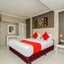 Natural Beach Hotel Pattaya guest room with bed, red accents, wall art, and side table in Pattaya