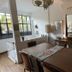 Le Petit Palais Buenos Aires dining room with wooden table, wall art, mirrors and large window