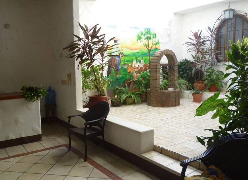 Hotel Casa Vieja, Puerto Escondido courtyard with potted plants, mural, and brick archway