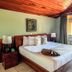 Hotel Montaña Monteverde room in Santa Elena with king bed, wood ceiling, and balcony doors