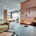 Zenitude Hotel Residences - Grenoble Alpexpo room with seating area, bed, and wood slat divider in Grenoble
