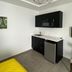 Hotel Nest in San Juan kitchenette with black cabinets, mini fridge and geometric pendant light