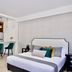Rio Suites in Tijuana: studio with king bed, kitchenette, and two green bar stools