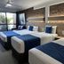 Logan City Motor Inn in Slacks Creek: guest room with three beds and brick accent wall