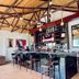 Infinity Hotel Kampala bar and lounge with high stools, hanging lights, and exposed wooden ceiling in Kampala