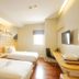 Citihub Hotel @Pecindilan Surabaya room with two twin beds, wall mural, desk, and wall-mounted TV