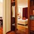 Al Tezzon Hotel in Camposampiero: guest working in a lounge beside a bedroom with open wardrobe