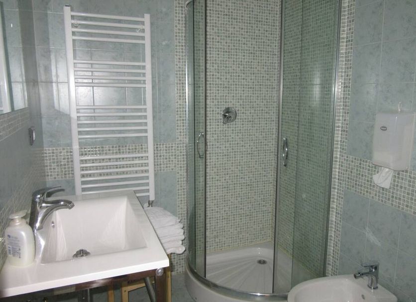 Il Borgo di Campi bathroom with sink, towel radiator, and glass-enclosed shower in Riomaggiore
