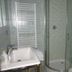 Il Borgo di Campi bathroom with sink, towel radiator, and glass-enclosed shower in Riomaggiore