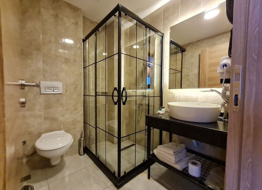Air Boss Istanbul Airport and Fair Hotel bathroom with glass shower, vessel sink and wall-mounted toilet in Istanbul