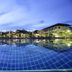 Kuiburi Hotel & Resort in Prachuap Khiri Khan with a lit outdoor pool at dusk and palm trees