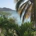 Green Roof Inn in Carriacou with tropical palms overlooking a calm bay and mountain coastline
