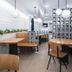 Gravity Haus Revelstoke lounge with wooden tables, benches, hanging globe lights and grid wall dividers