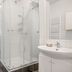 Stay Apartments Einholt Reykjavik bathroom with glass shower enclosure and white tile walls
