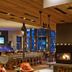 Topnotch Resort Stowe lounge with bar, fireplace, and large windows overlooking the evening view