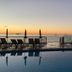 Apartamentos Sal Rossa in Sant Josep de sa Talaia, oceanfront pool deck at sunset with loungers and umbrellas