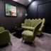 Garni Hotel Zen, Niš: cozy lounge with green armchairs, small table, and dark wood walls