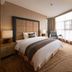 Xinhua Jianguo Hotel in Jiujiang guest room with king bed, armchair, and large window
