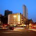 Yanjiang East Garden Inn in Guangzhou at dusk, with city street traffic and illuminated hotel exterior.