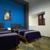 Hotel Posada Don Matias Oaxaca room with two double beds, blue accent wall, and framed artwork