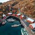 Nusfjord Village & Resort in Ramberg, harbor cabins beside a calm inlet and autumn hills