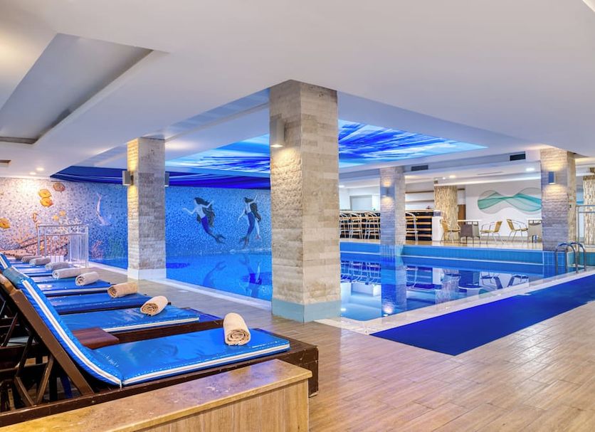 Sealife Family Resort Hotel in Antalya indoor pool with underwater dolphin mural and lounge chairs