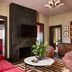 Zelda Dearest Asheville guest room with red sofa, marble coffee table, wall TV and striped rug